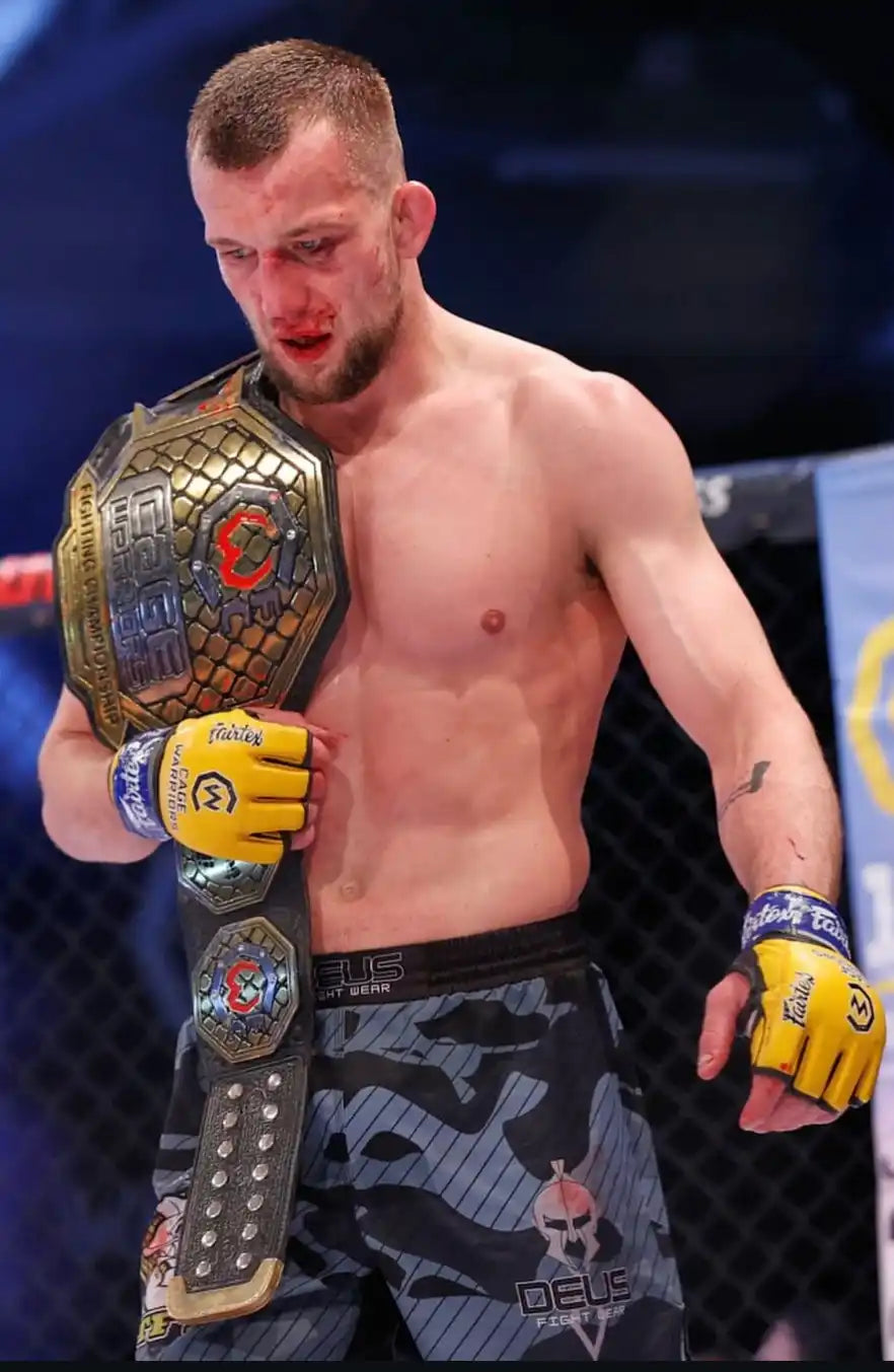Triumphant fighter with championship belt.